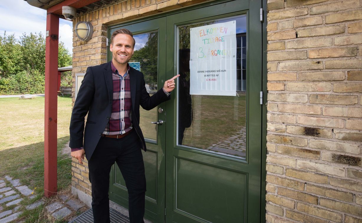 På alle døre til skolen er der plakater, som viser hvilke klasser, der må benytte indgangen. Efter fotografens ønske, stiller Marco Damgaards sig beredvilligt op med en pegende finger for at henlede læserens opmærksomhed på budskabet. Foto: Jan Klint Poul