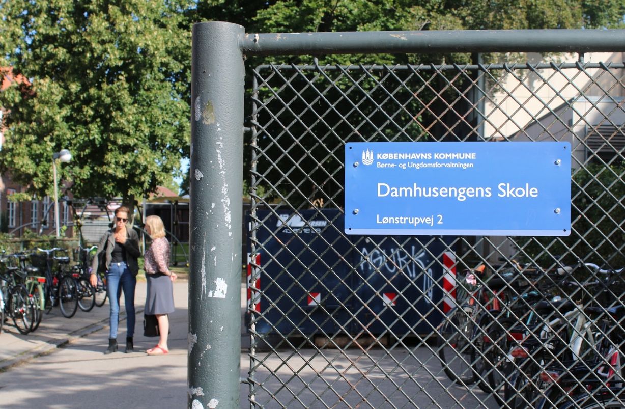 Tillidsrepræsentant Charlotte Forsberg får en hurtig snak med en kollega i solen ved indgangen til den nye Damhusengens Skole. Foto: Andreas Brøns Riise.