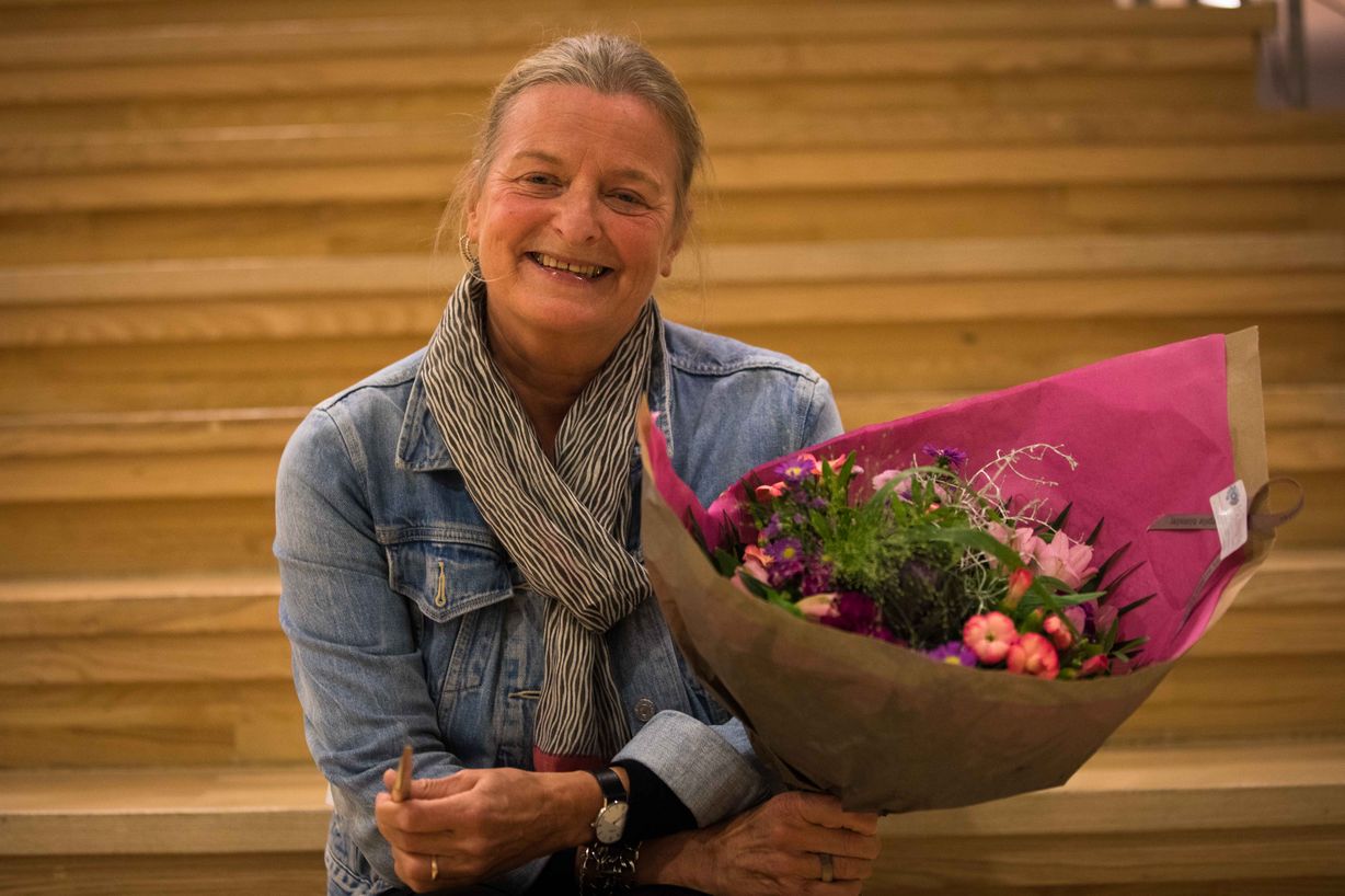 En glad prisvinder med gylden pegepind og blomster. Foto: Jan Klint Poulsen